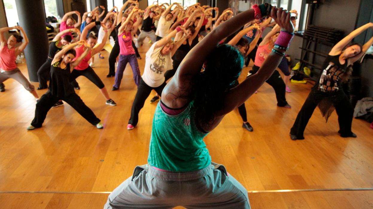 Una entrenadora junto a un grupo haciendo deporte