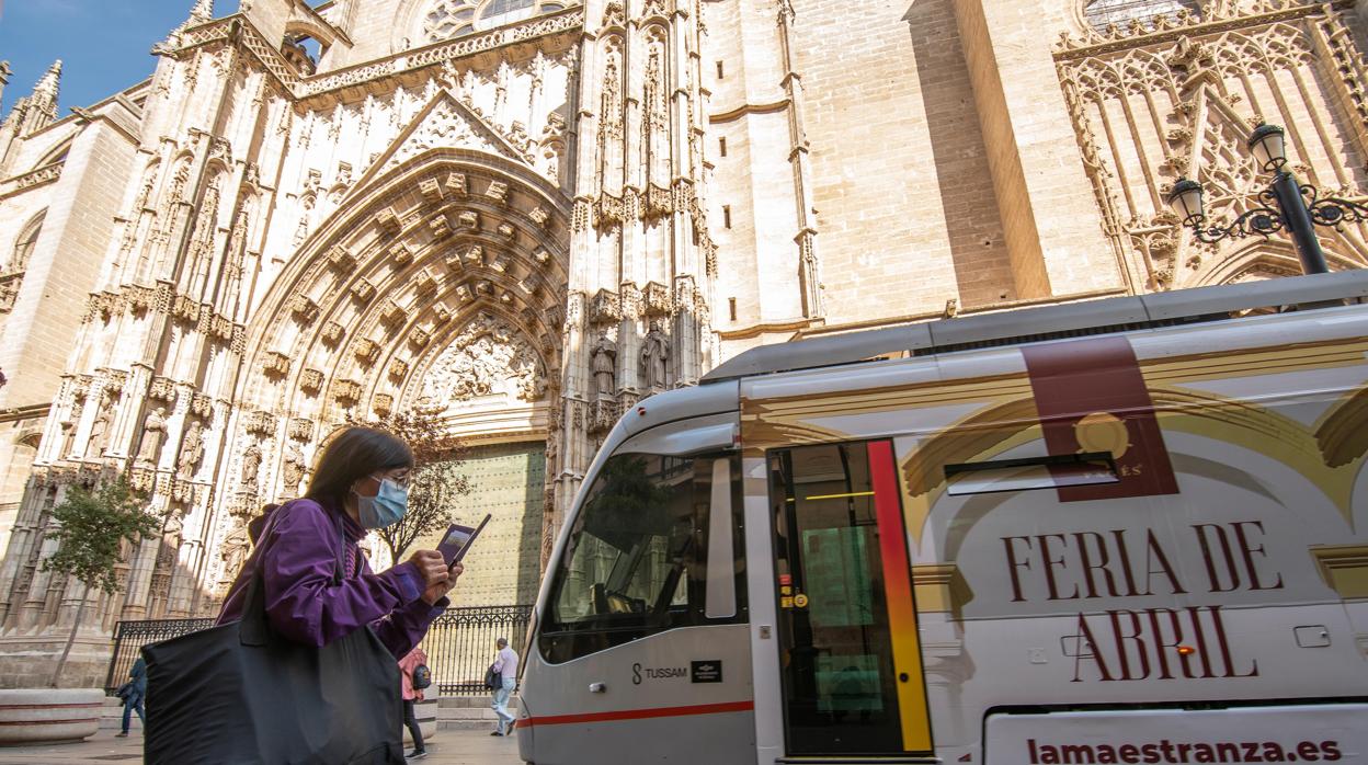 Una persona con mascarilla frente a la Catedral de Sevilla