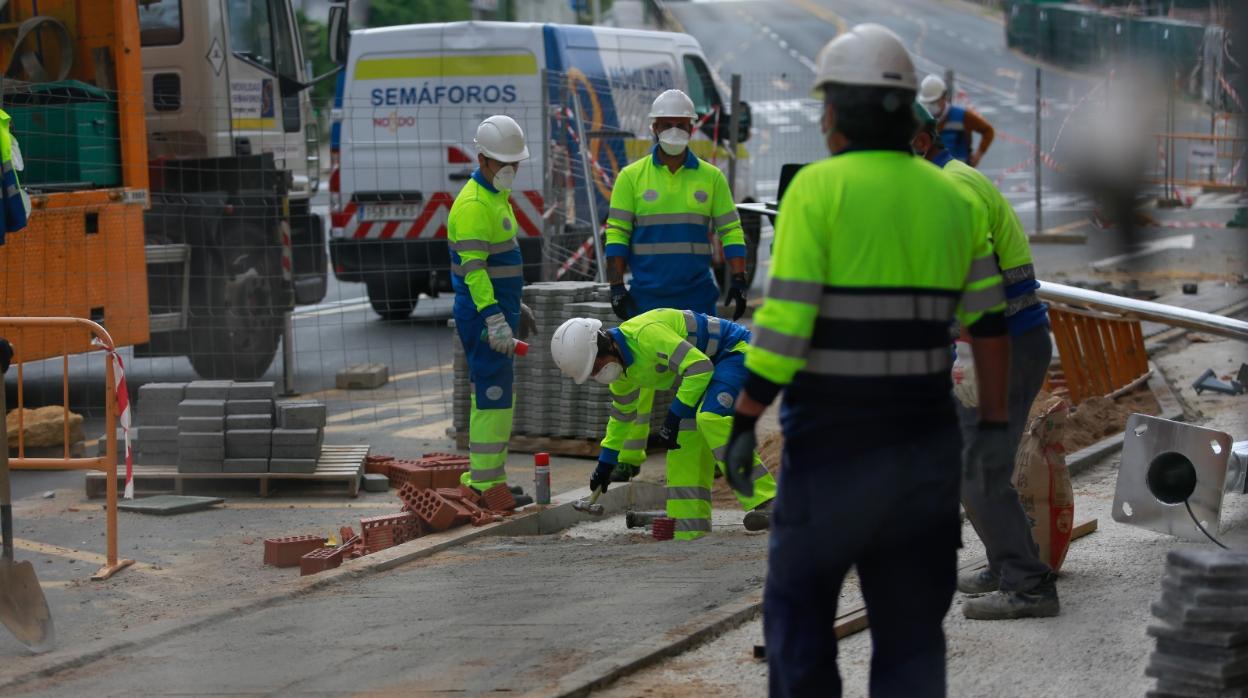 Operarios de una contrata trabajando ayer en una acera de Sevilla