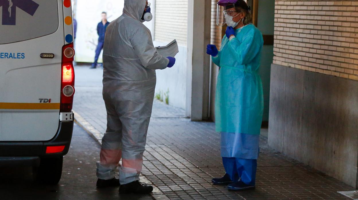 Dos sanitarios dialogan a las puertas de un centro hospitalario de Sevilla