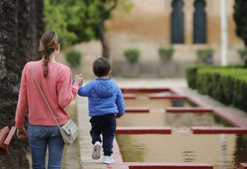 Un pequeñín, de la mano de su madre en el Parque