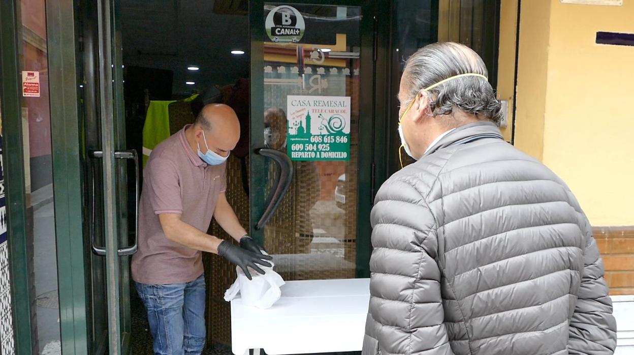 Un bar de Sevilla entrega comida en la puerta del local a un cliente