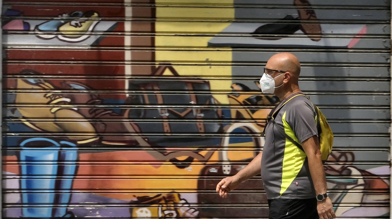 Un hombre camina con poco abrigo por las calles de Sevilla