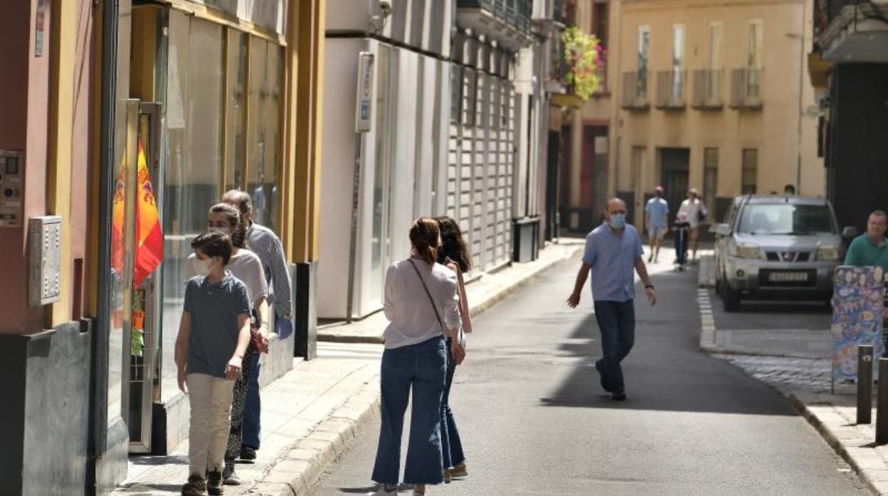 Peatones por la calle Águilas de Sevilla, cerrada al tráfico rodado para pasear