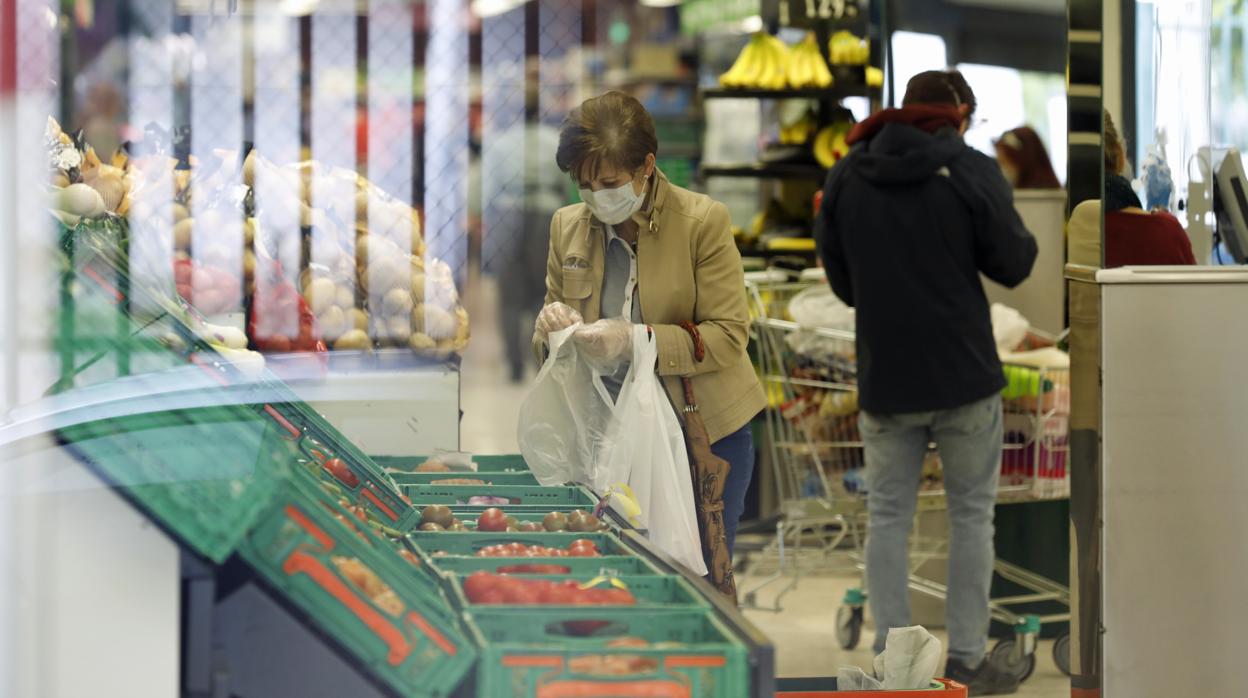 Una señora en el departamento de frutas y verduras de un supermercado Mercadona