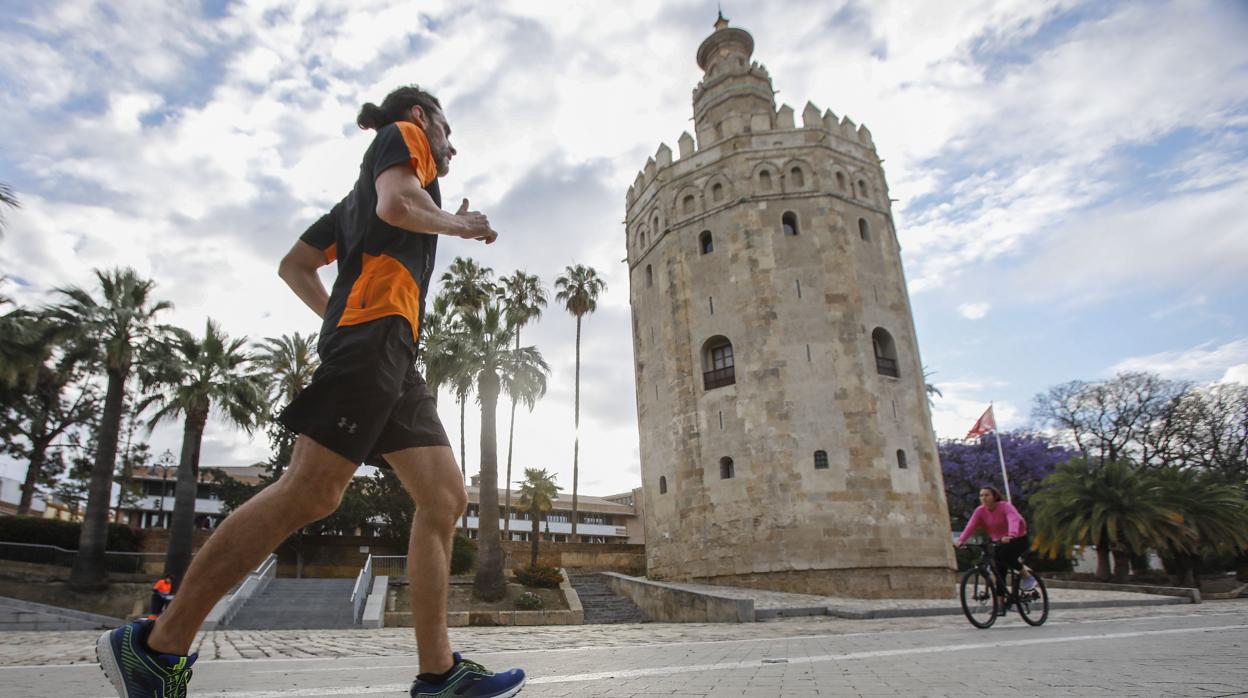 Dos personas hacen deporte bajo un cielo poco cubierto en Sevilla