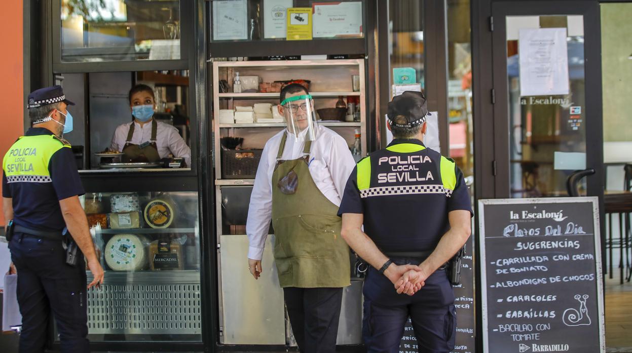 Agentes de la Policía Local de Sevilla inspeccionan un bar de la capital