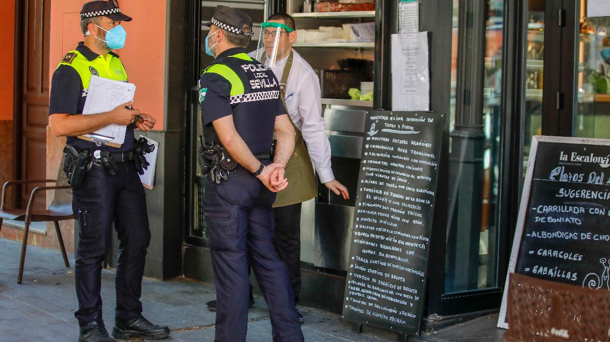 Dos agentes de Policía Local ante un negocio sevillano