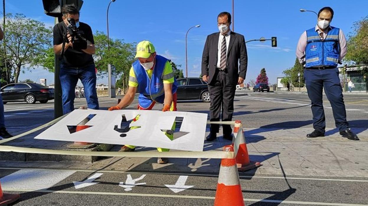 Momento en el que operarios del Ayuntamiento de Sevilla pintan las flechas en los pasos de peatones