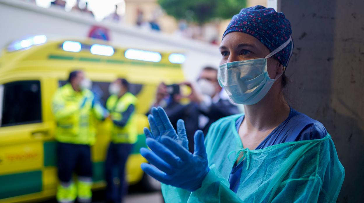 Una profesional sanitaria aplaude a las puertas del Hospital Virgen del Rocío