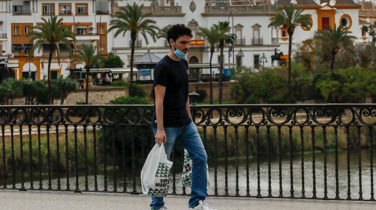 Un hombre cruza el puente de Triana