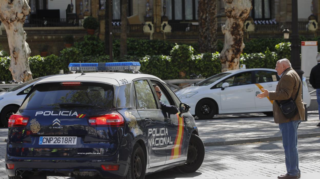 Un patrullero de Seguridad Ciudadana atiende a un viandante en la Puerta de Jerez