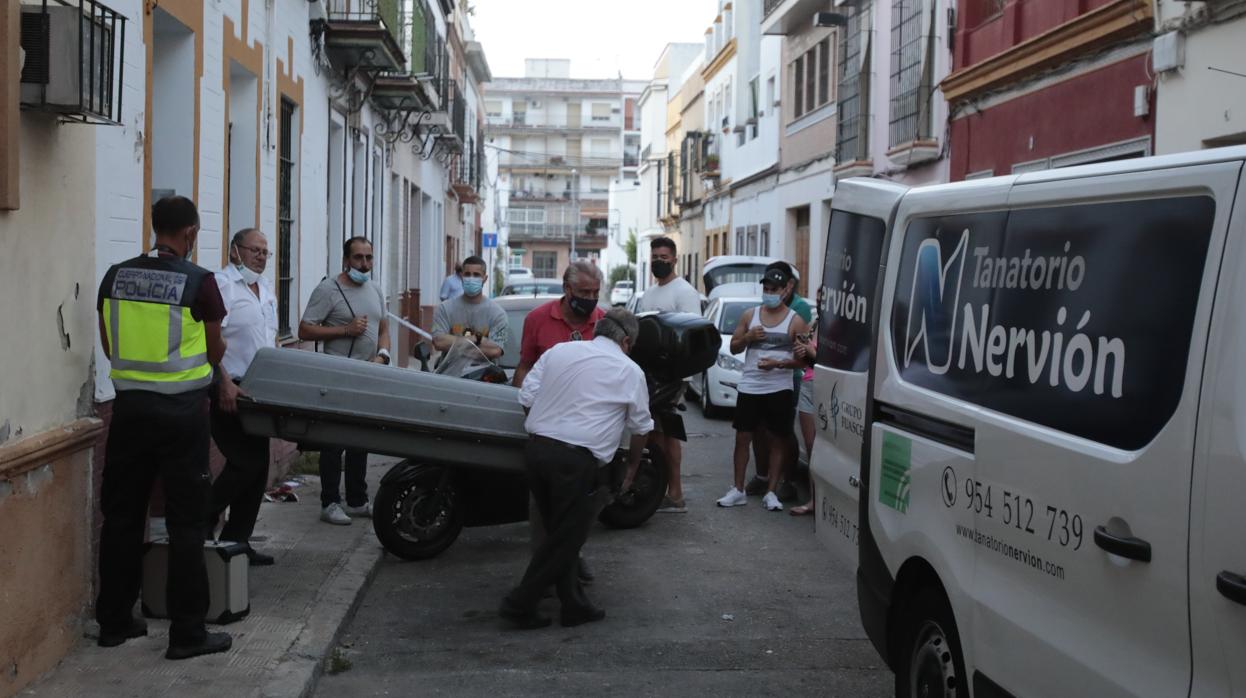 Los operarios de la funeraria sacan el cadáver de la mujer fallecida en el incendio