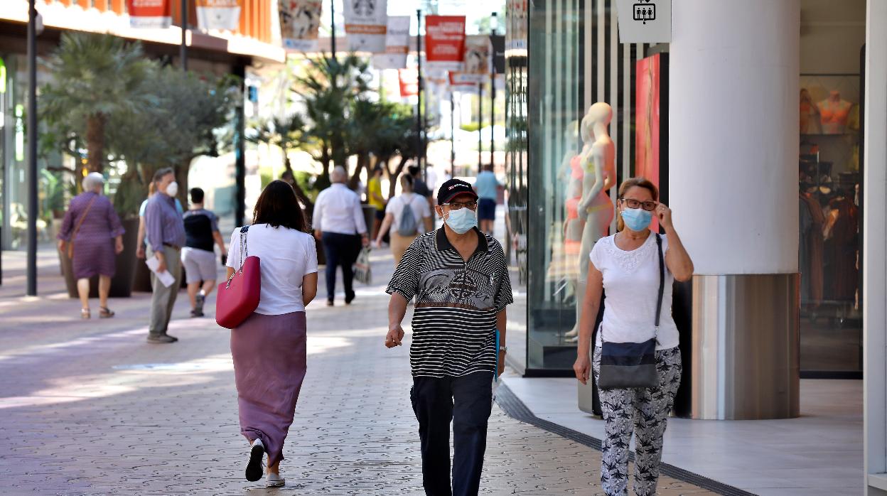 Dos personas con mascarilla en la calle