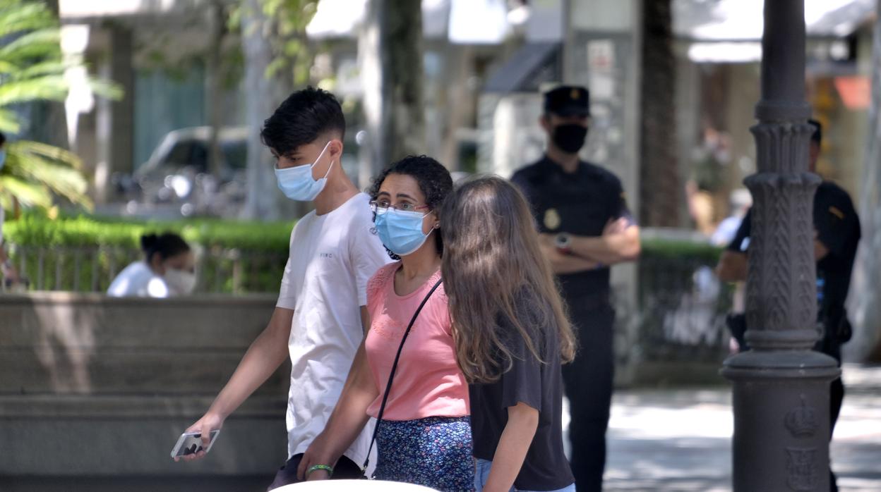 Tres jóvenes pasean por una de las calles del Centro de Sevilla