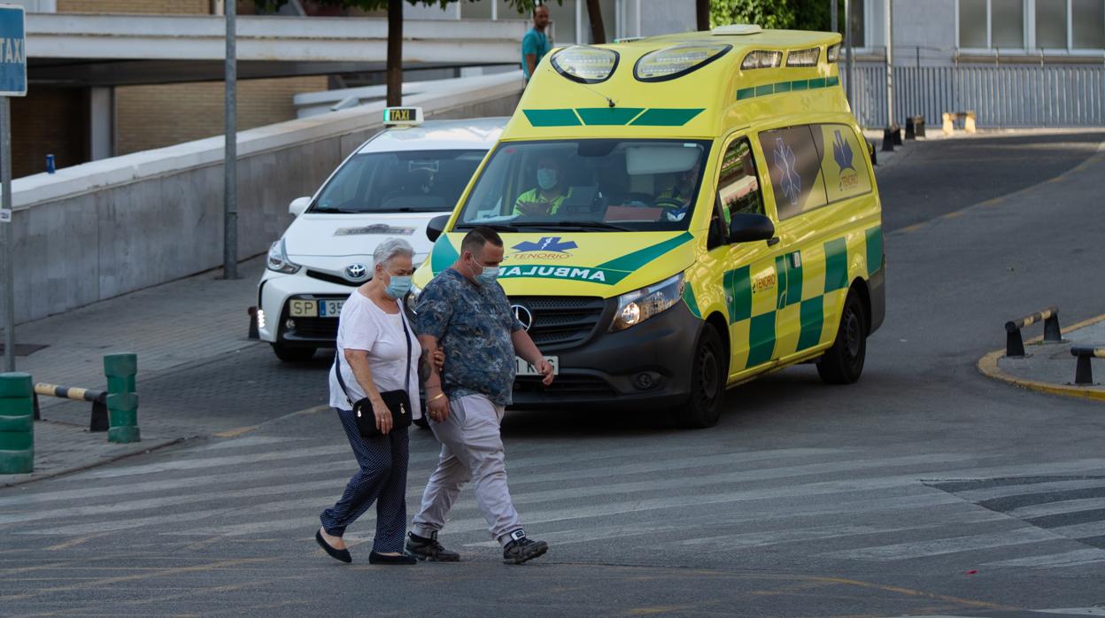 Dos personas cruzan un paso de peatones en las inmediaciones del Hospital Virgen del Rocío