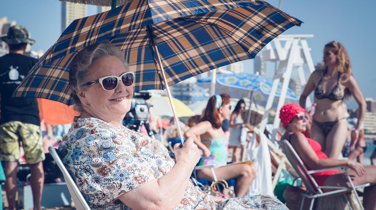 María Galiana sentada en la playa bajo un parasol