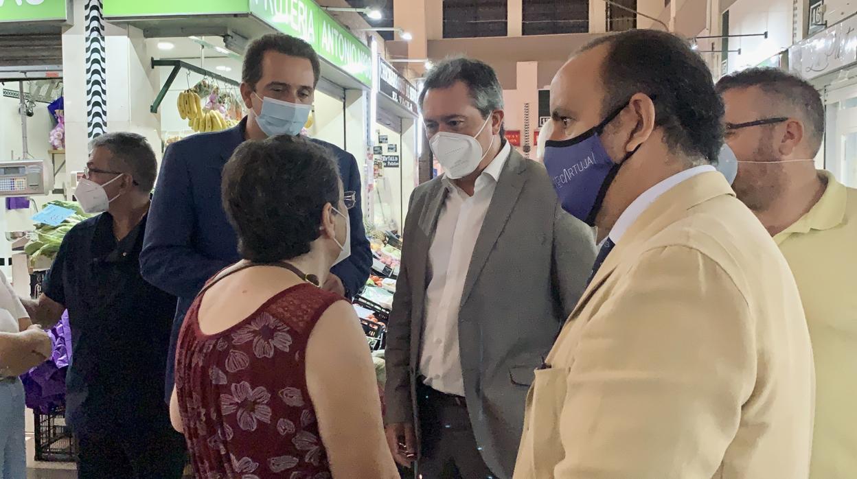 Juan Espadas charla con una clienta en el mercado de Pino Montano