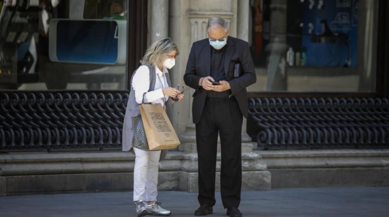 Dos personas con mascarilla en el Centro de Sevilla