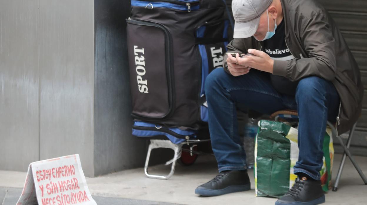 Una persona sin hogar pide ayuda en una calle de Sevilla