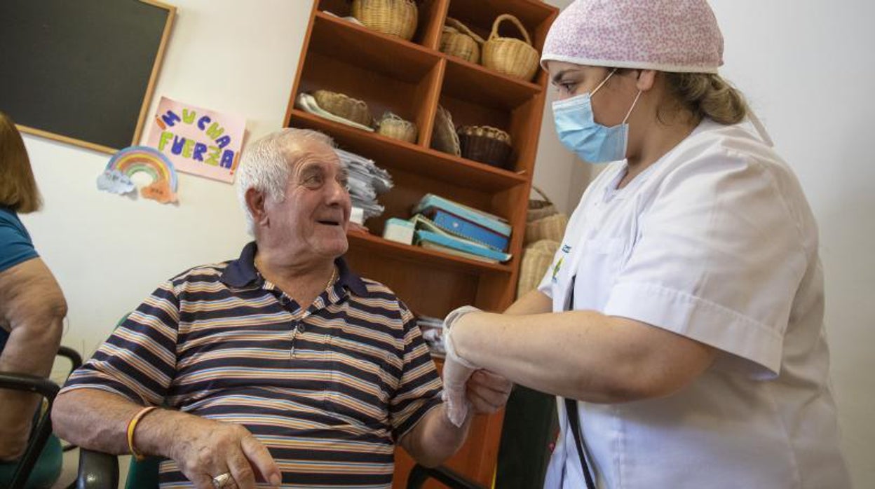 Un residente de un centro junto a una auxiliar de geriatría