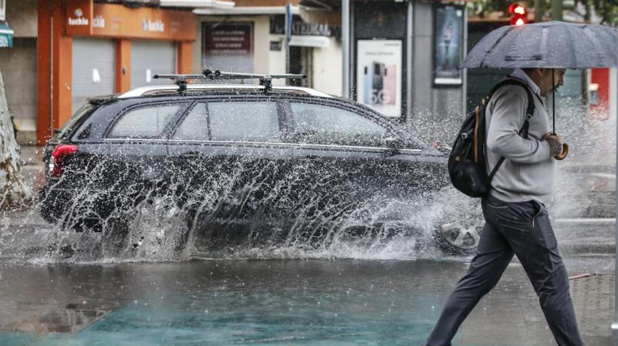 Un coche salpica agua en Sevilla en un día de lluvia