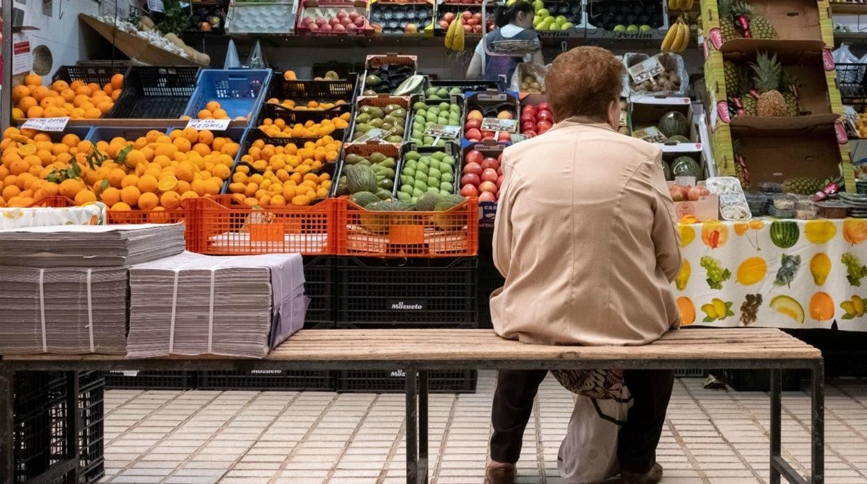 Una señora espera su turno sentada en el mercado del Tiro de Línea