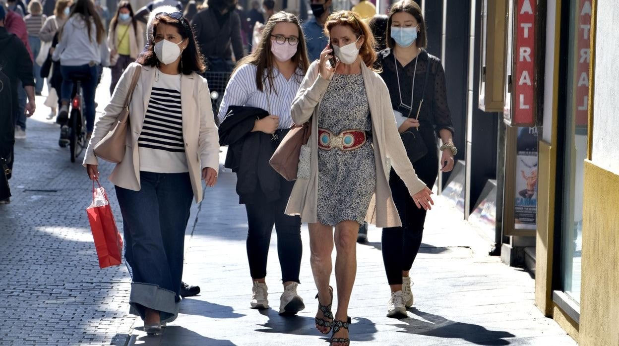 Mujeres paseando por Sevilla, todas con la preceptiva mascarilla