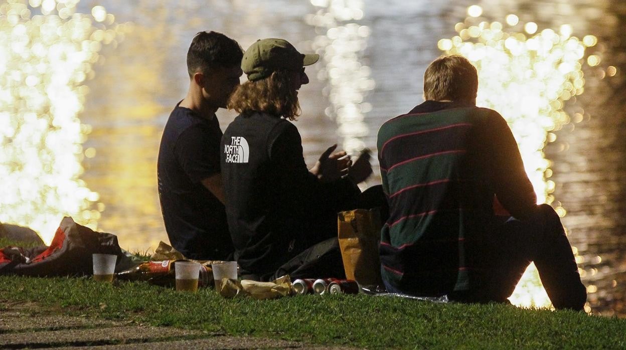 Unos jóvenes participan en un botellón junto al río