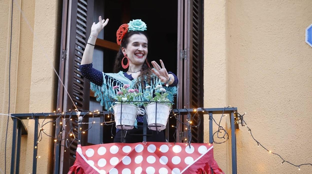 Una mujer celebra «la Feria» desde el balcón de su casa