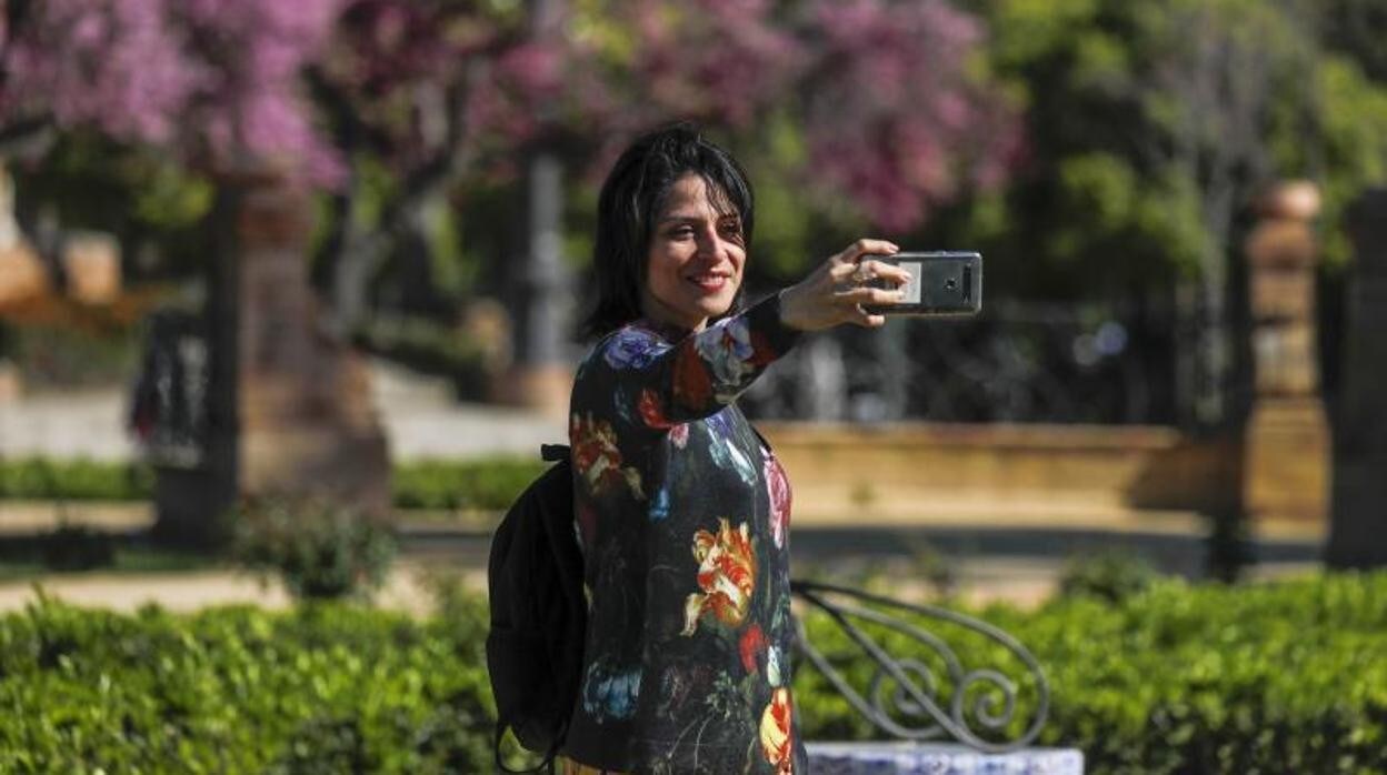 Una joven se hace una foto en el Parque de María Luisa