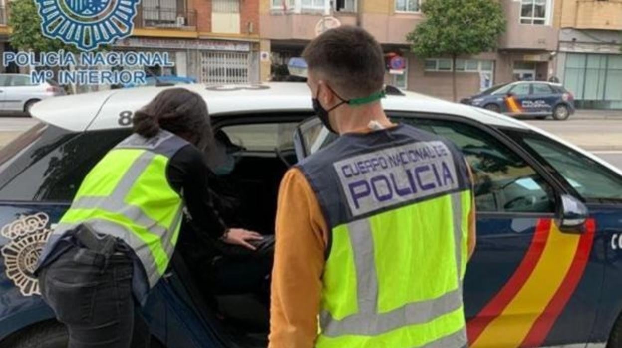 Los agentes de la Policía Nacional introducen en un coche a uno de los detenidos