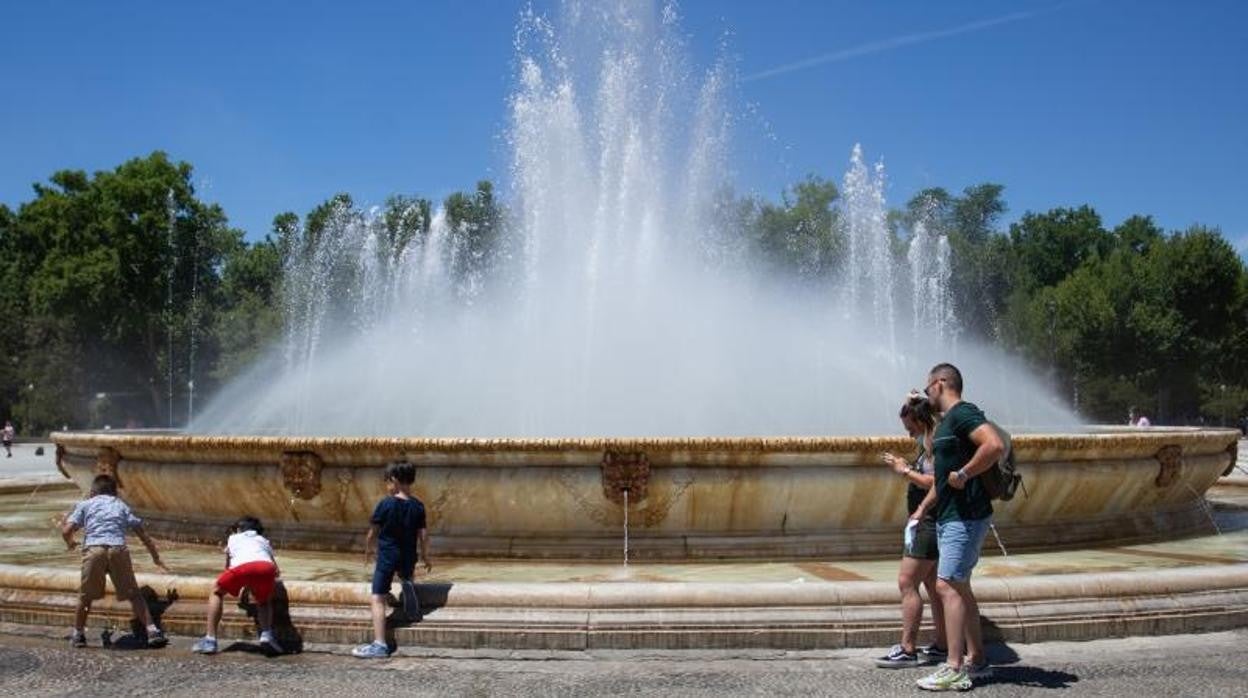 Varias personas pasean por la Plaza de España de Sevilla y buscan la fuente central para refrescarse