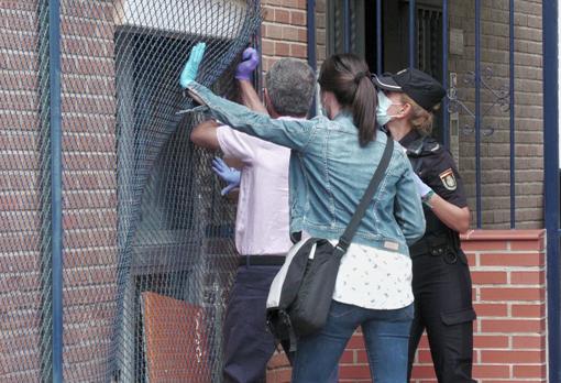 Los agentes tratan de colocar la reja que cerraba la ventana por donde se coló un policía