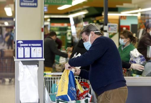 Un hombre recoge su compra en Mercadona