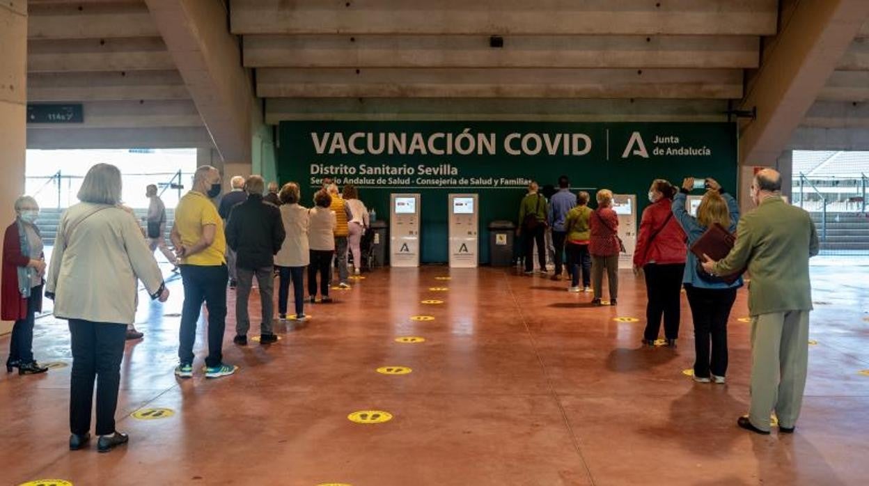 Un grupo de personas aguarda su turno para ser vacunados en el estadio de la Cartuja