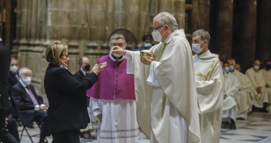 El nuevo prelado sevillano, dando la comunión a su hermana, que asistió al acto