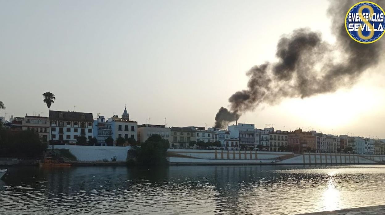 Aspecto de la columna de humo causada por el incendio producido en unas viviendas de la calle Pureza