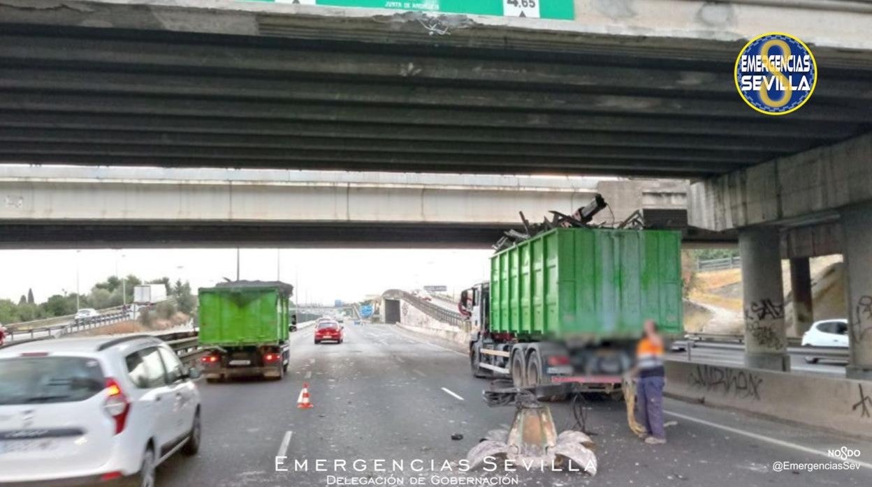 El camión que ha chocado con el puente de la SE-30, con la grúa caida en el suelo