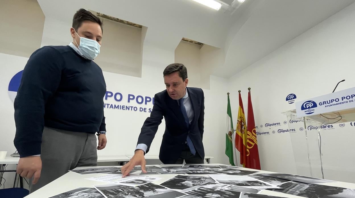 Los concejales del PP Juan de la Rosa y José Luis García, con fotos de la asociación subvencionada