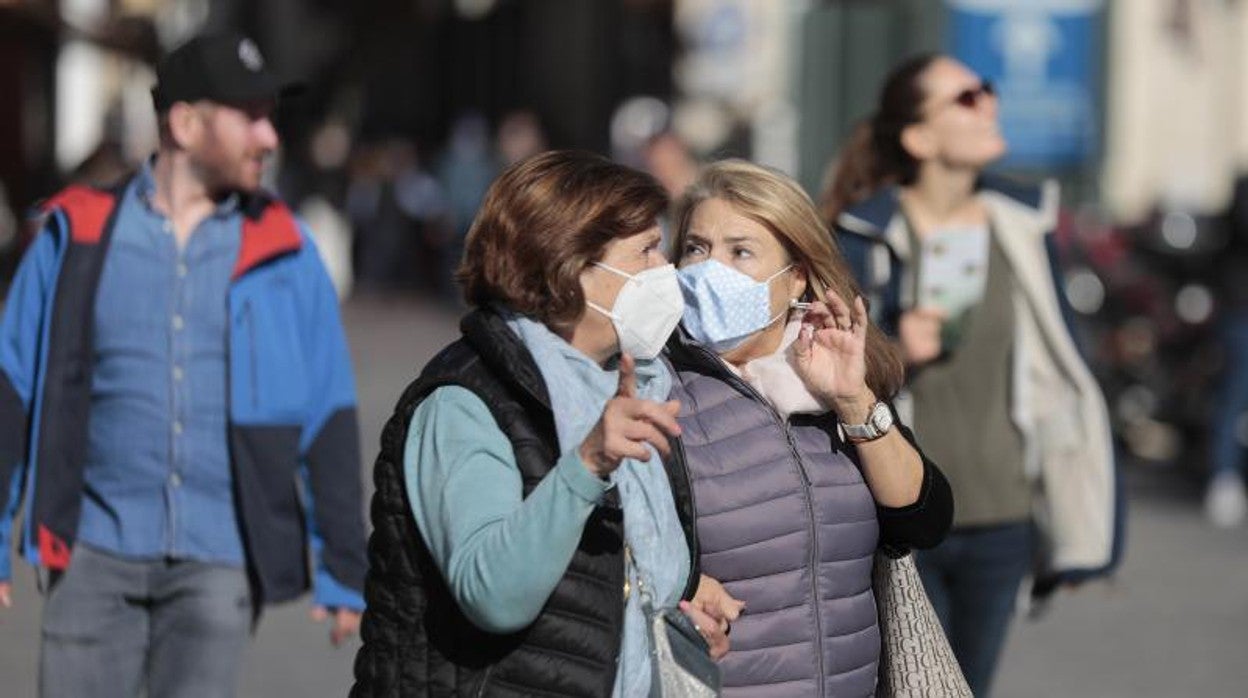 Dos mujeres pasean por la calle con sus mascarillas