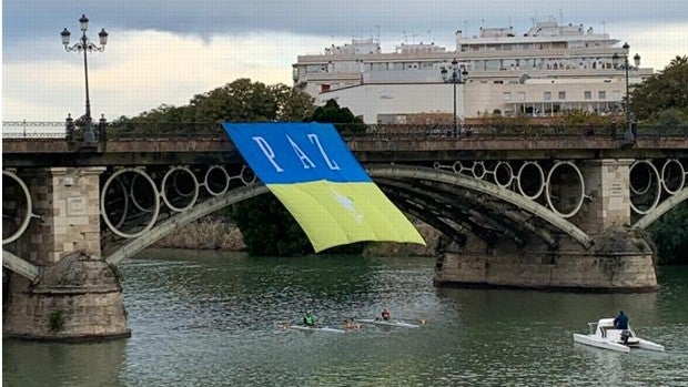 Una bandera de Ucrania luce sobre el puente de Triana para pedir la paz