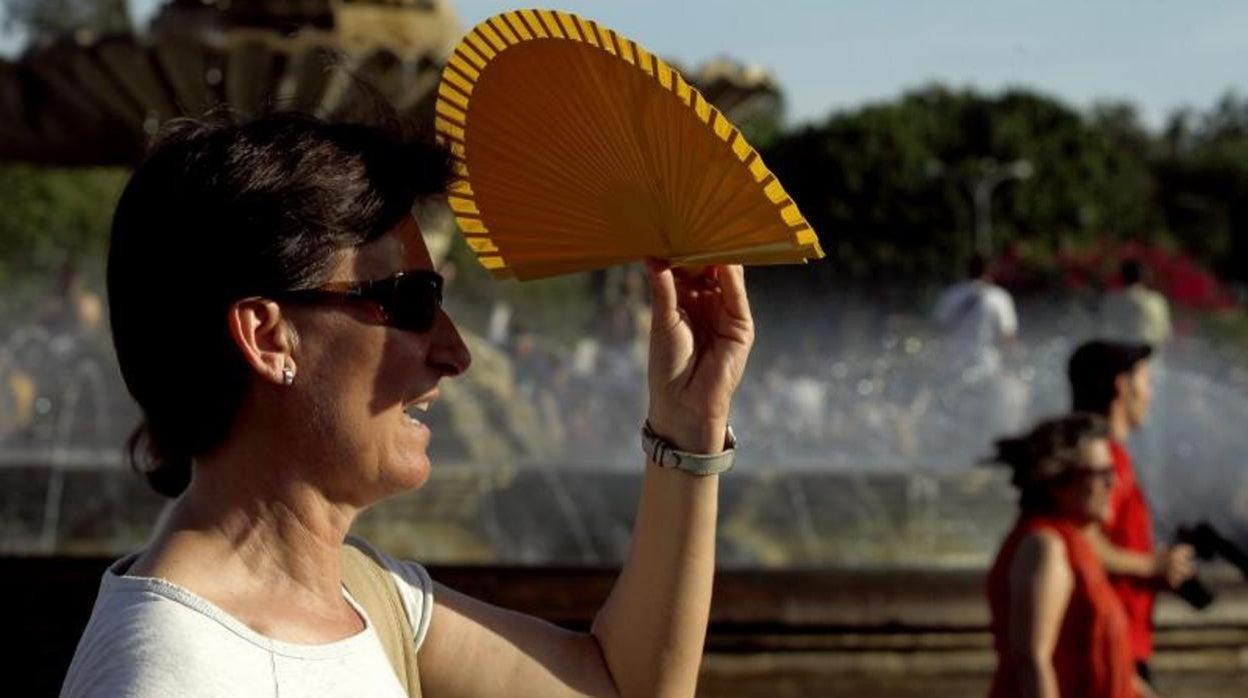 Una mujer se protege del Sol en Sevilla capital