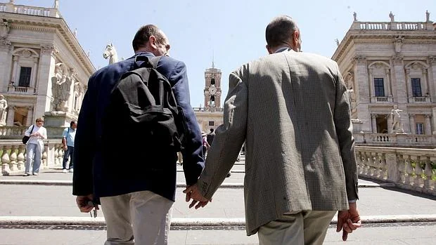 Una pareja gay camina de la mano hacia la Plaza Ampidoglio, donde está situado el ayuntamiento de Roma, capital de Italia