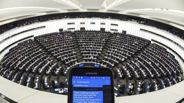 Una persona muestra un SMS con información de «roaming» en su móvil durante el pleno del Parlamento Europeo