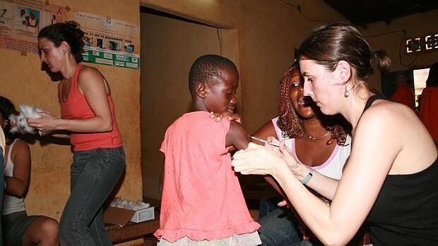 Una cooperante vacuna a un niña en Costa de Marfil
