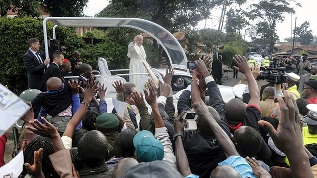 El papa Francisco (dcha) saluda a los fieles a su llegada al barrio de Kangemi en Nairobi