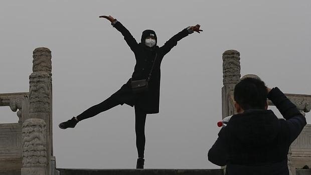 Una mujer posa para una foto mientras usa una mascarilla para protegerse contra la contaminación