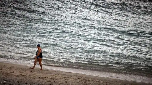 Una señora salía del agua en la Playa de Riazor