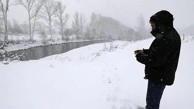Un hombre observa el temporal de nieve en la localidad de Boñar (León)